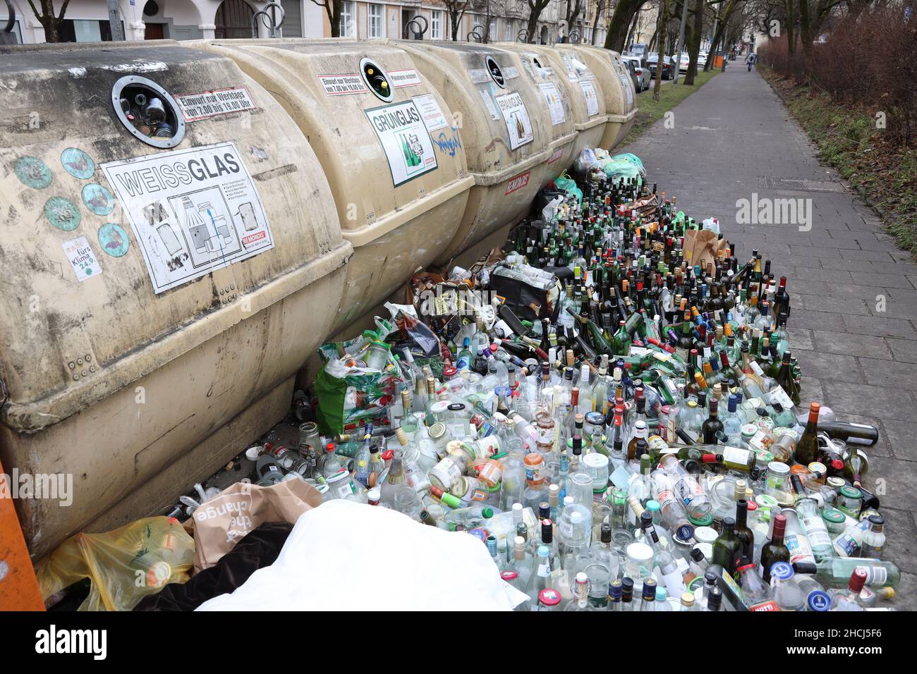 Overflowing recycling glass bottle containers with rows of bottles