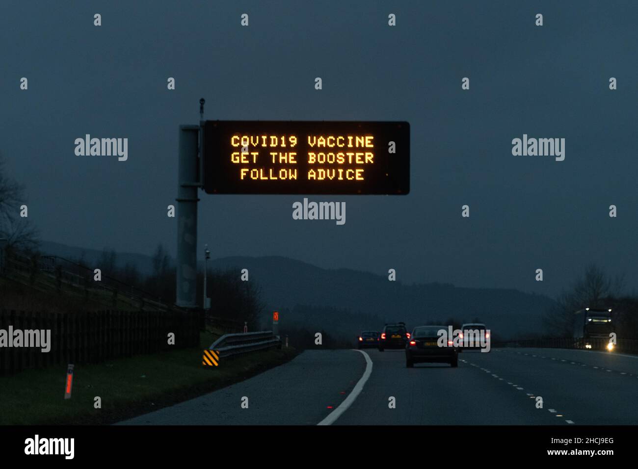 Scotland, UK. 29th Dec, 2021. The Covid-19 booster push in Scotland includes giant 'Covid-19 Vaccine Get the Booster Follow Advice' motorway gantry signs. Pictured - sign on M74 motorway heading north towards Glasgow Credit: Kay Roxby/Alamy Live News Stock Photo