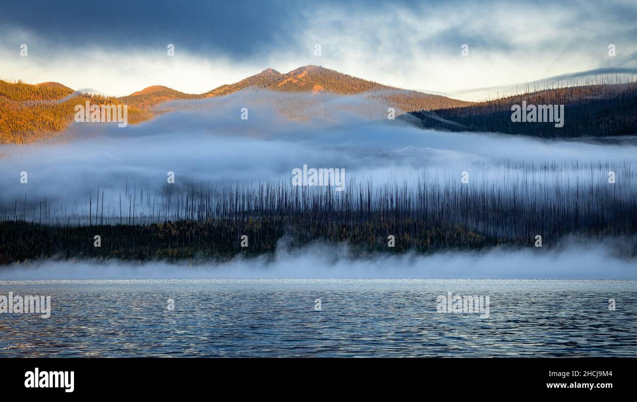 Beautiful view of a lake with mountains covered with fog Stock Photo