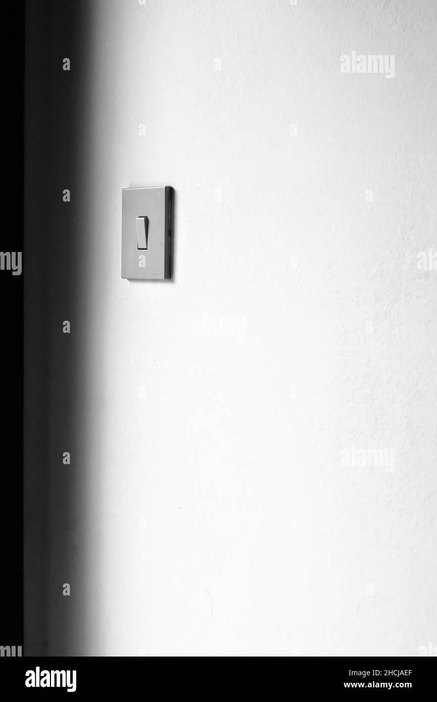 Vertical shot of a light switch on a white wall Stock Photo