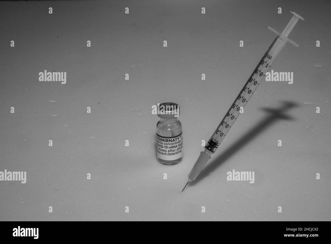 Bamberg, Germany - 16.11.2021. Vial of vaccine from Biontech-Pfizer Cormirnaty and a vaccination syringe against a white background Stock Photo