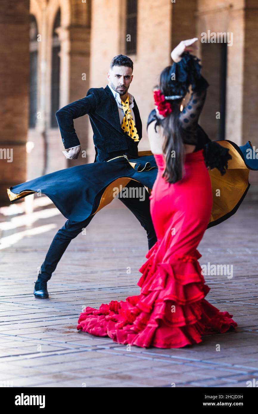 Man with a cape dancing flamenco with a woman in dress outdoors Stock Photo