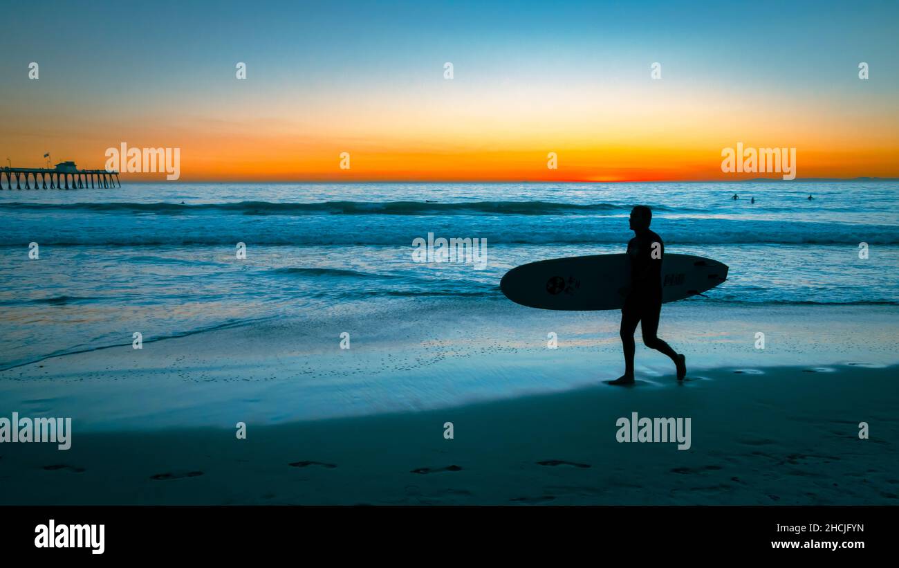 Silhouette of a guy going to surf at the San Clemente beach Stock Photo