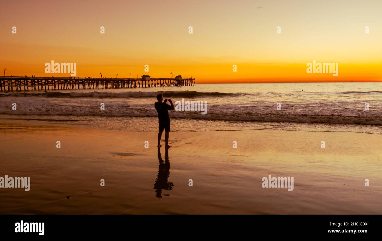 Silhouette of a guy taking a landscape picture of the san clement seashore sunset Stock Photo