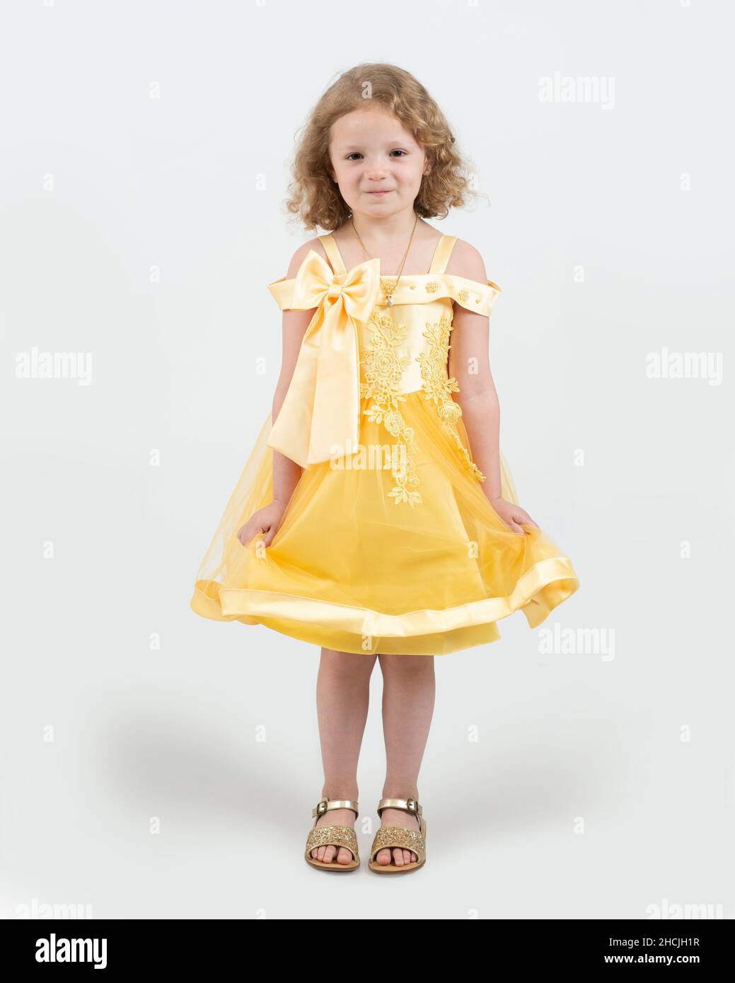 full length portrait of 4 or 5 year old girl, smiling, white background, in dressup dress Stock Photo