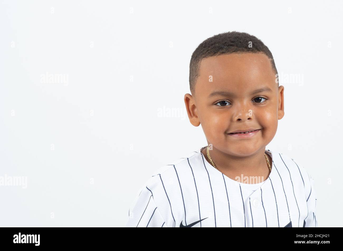Closeup portrait of 4 or 5 year old boy, smiling, white background Stock Photo