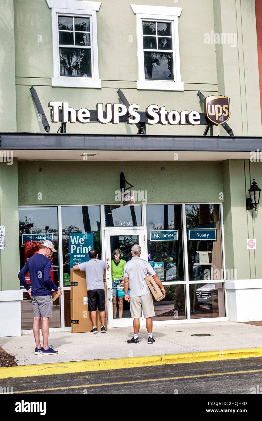 Port St. Saint Lucie Florida Tradition Village Center The UPS Store outside exterior entrance people waiting line queue Covid-19 restrictions capacity Stock Photo