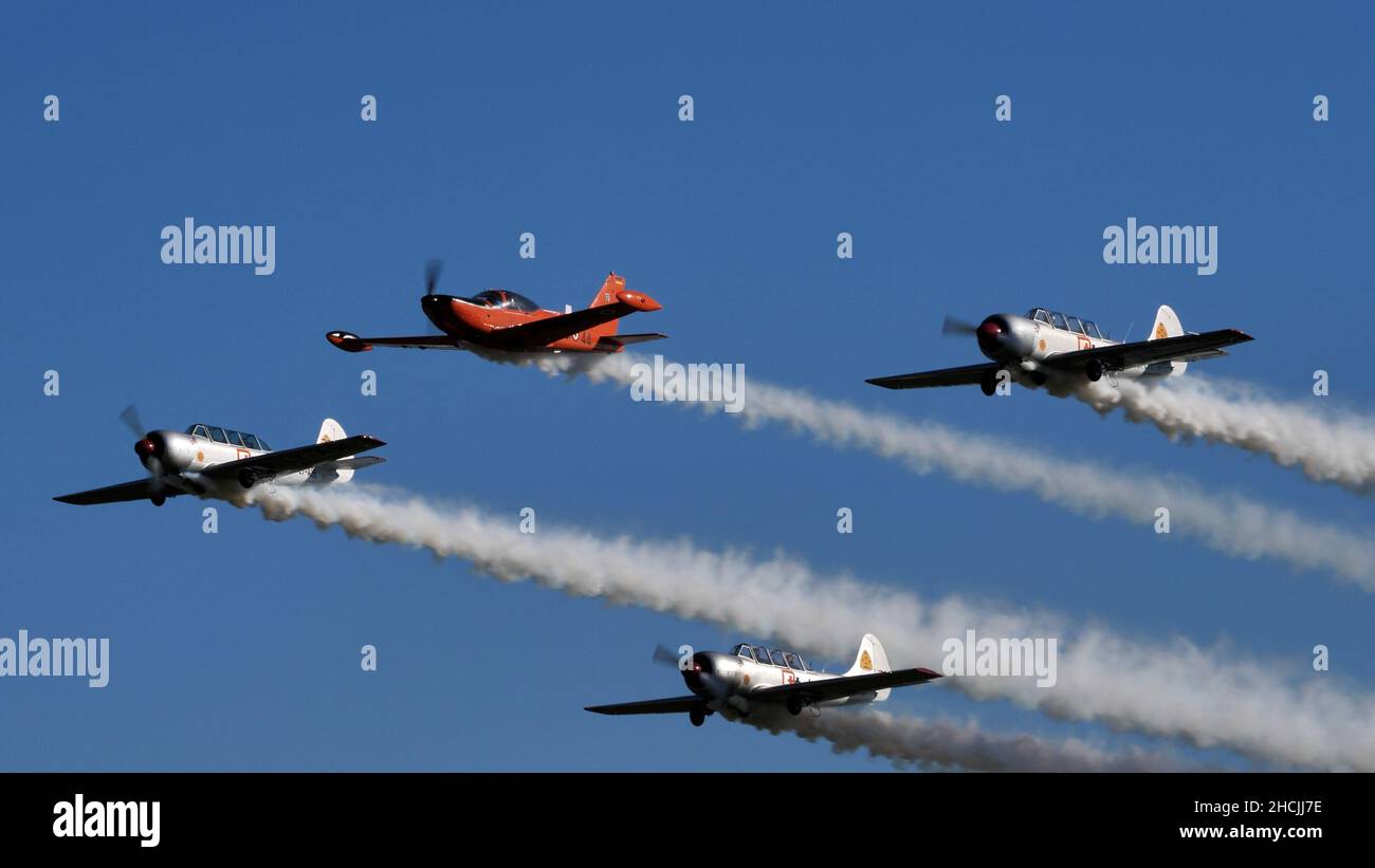 Thiene Italy OCTOBER, 16, 2021 Narrow formation of four propeller planes with smokes in blue sky. Teamwork concept with copy space. Yakovlev Yak-52 by YAK Italia Stock Photo