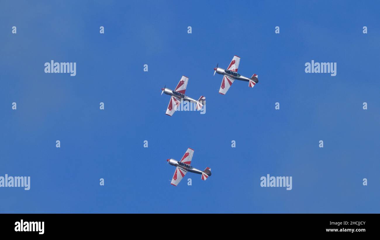 Thiene Italy OCTOBER, 16, 2021 Soviet propeller military planes in close formation in blue sky. Copy Space. Yakovlev Yak-52 by YAK Italia Stock Photo