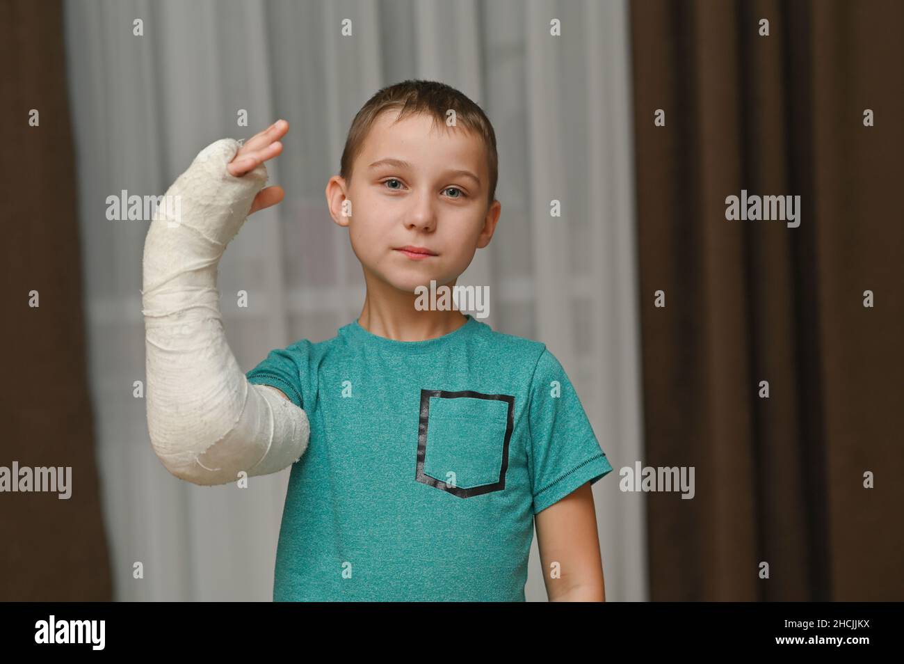 boy shows a broken arm in a cast. Stock Photo