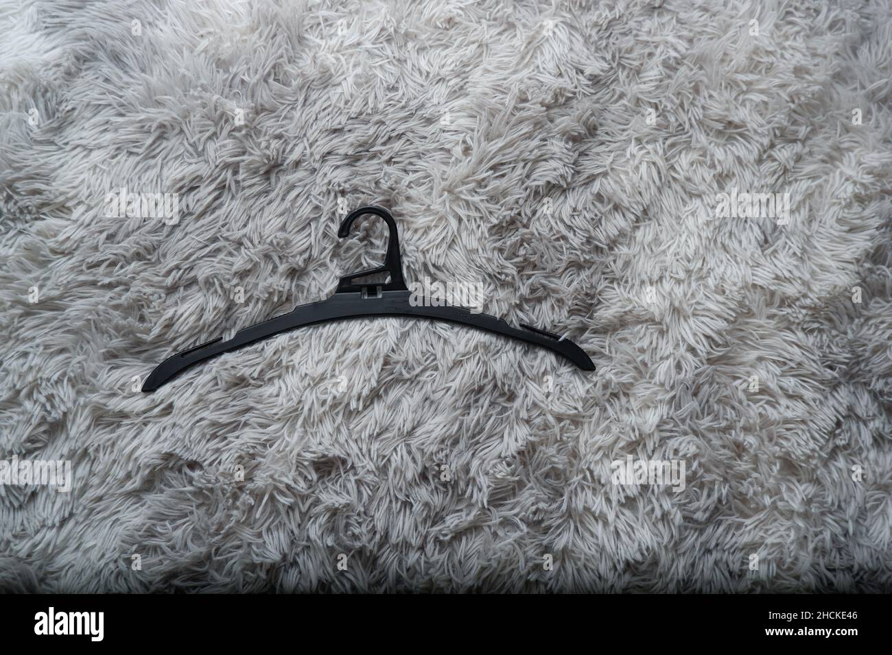 Single empty black hanger on gray background Stock Photo
