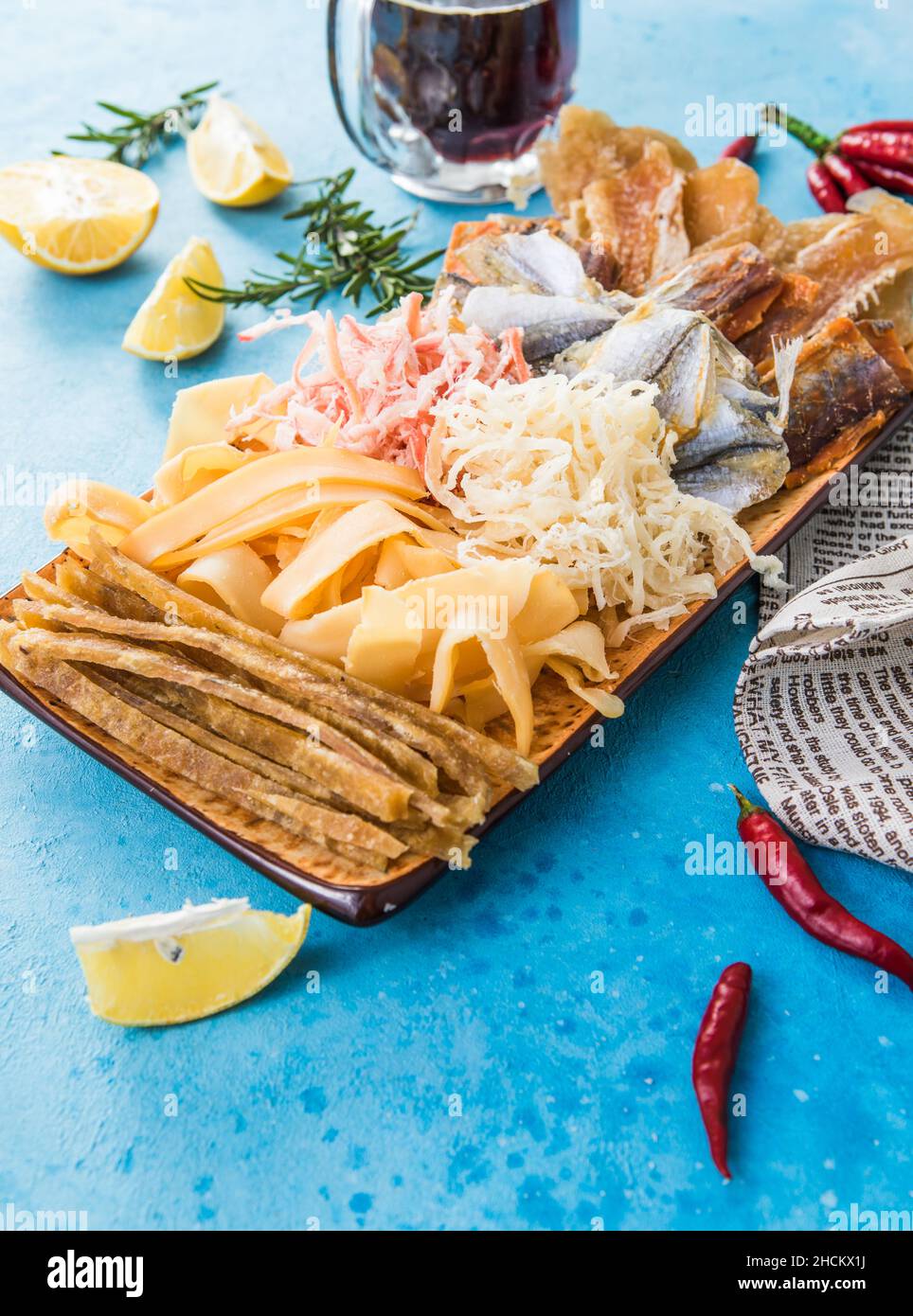 Dried Seafood Mix with Squid, Tuna, codfishon, yellow minke on Plate Top View. Cured Dehydrated Fish Fillet as Beer Snack Stock Photo