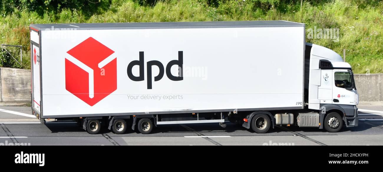 dpd business red parcel supply chain delivery lorry truck transport logo graphics in advertising on side articulated trailer driving along UK motorway Stock Photo