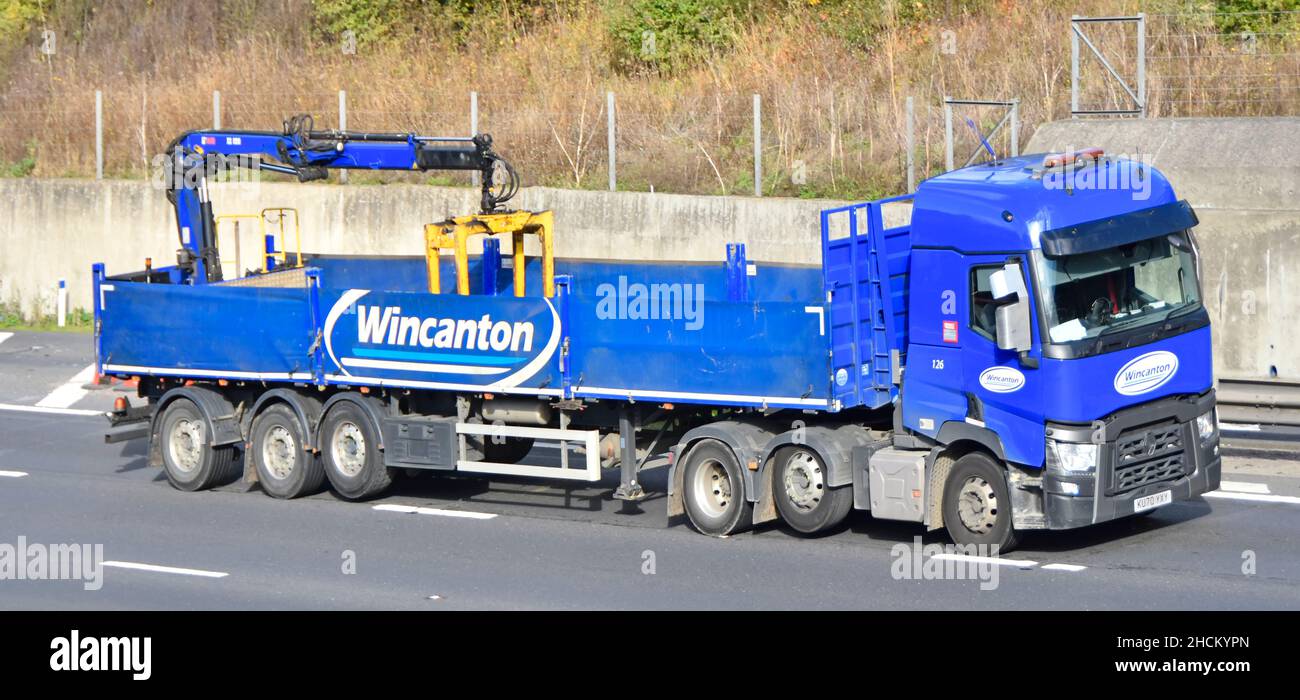 Wincanton logistics business lorry truck towing empty articulated trailer  with hydraulic crane offload equipment & raised axle driving UK motorway Stock Photo