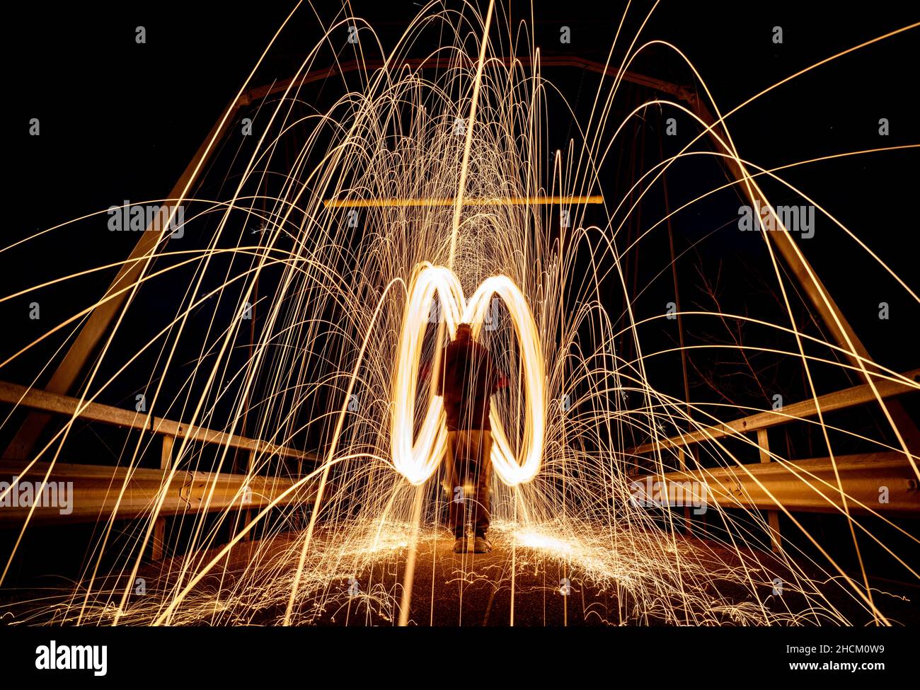 Man creating rotating and swirling sparks in a dark place Stock Photo ...