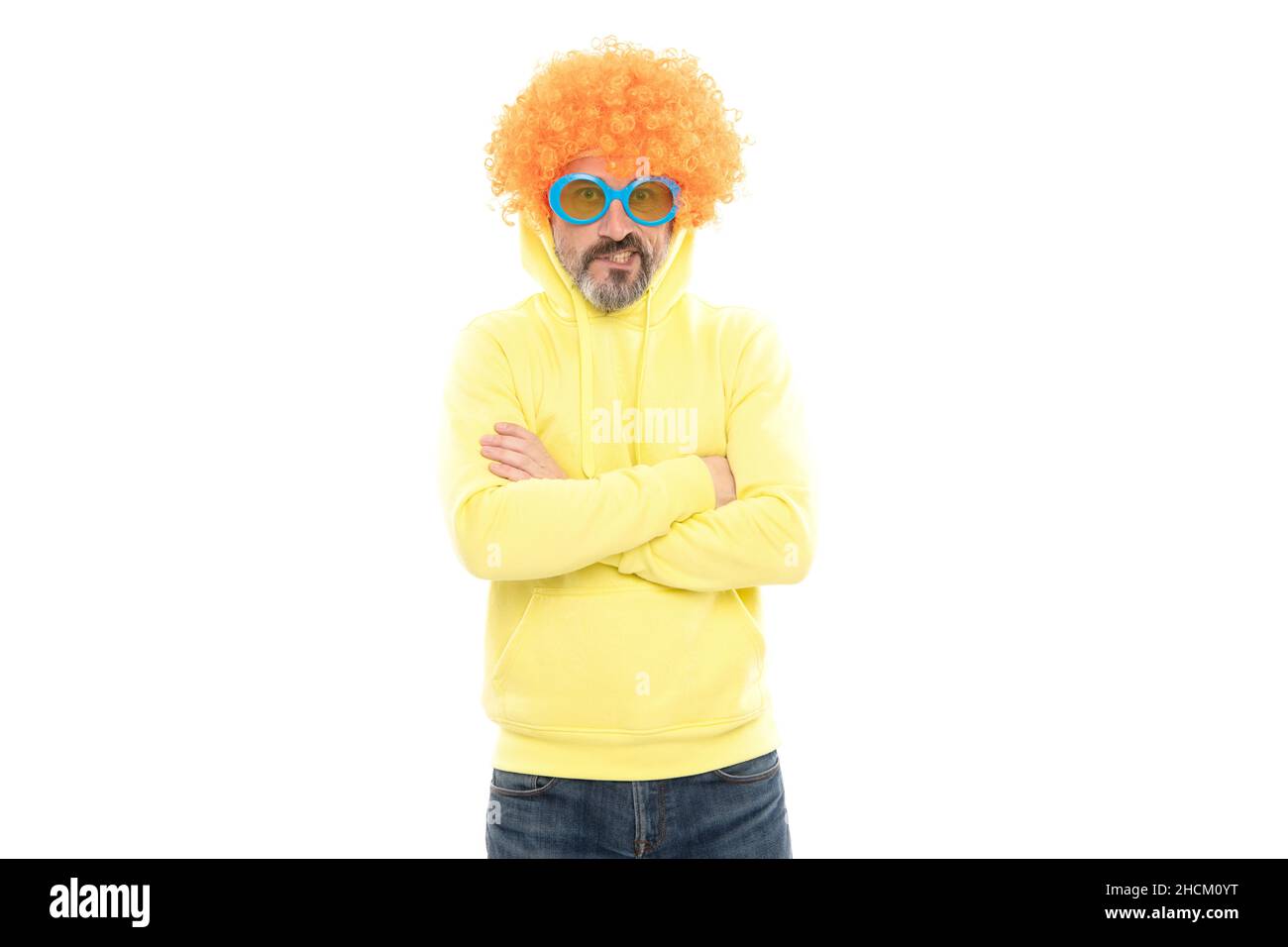 Funny man wear orange color wig with geeky look keep arms crossed, extravagant Stock Photo