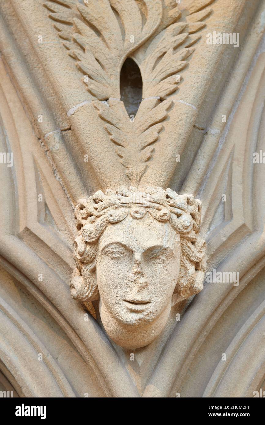 Defaced medieval sculpture of a royal male head, on a wall of the