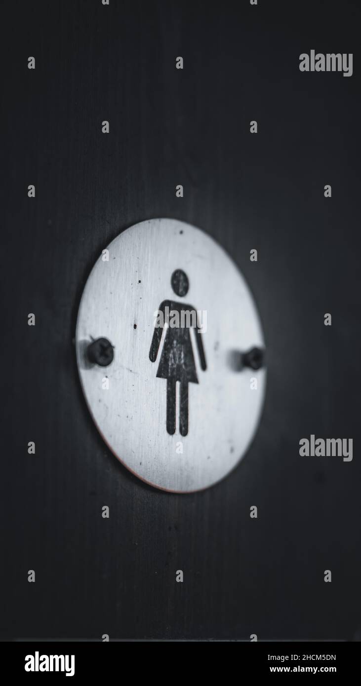 Vertical shot of a sign women toilet on a black background Stock Photo