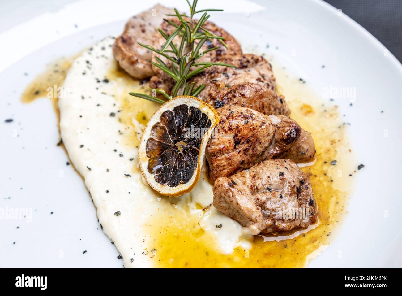 Closeup shot of cheese and grilled meat meal with a tranche of lemon Stock Photo