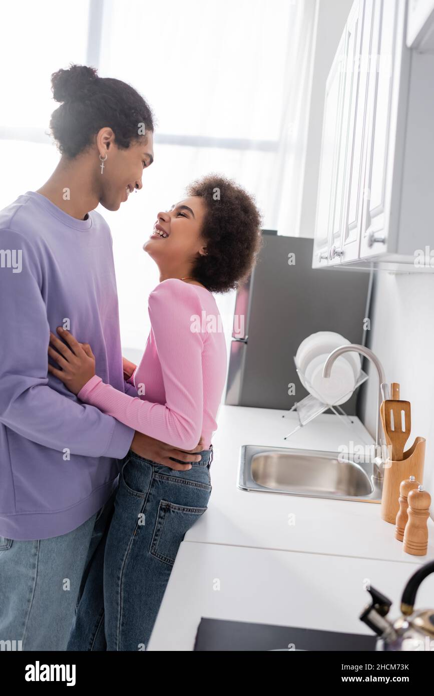 Side view of positive african american woman hugging boyfriend near ...