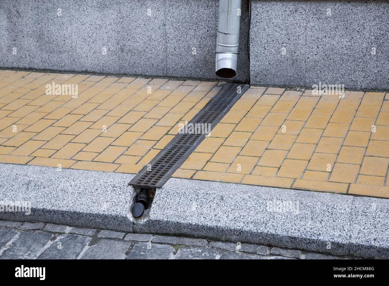 facade of building with granite stone cladding with downspout into