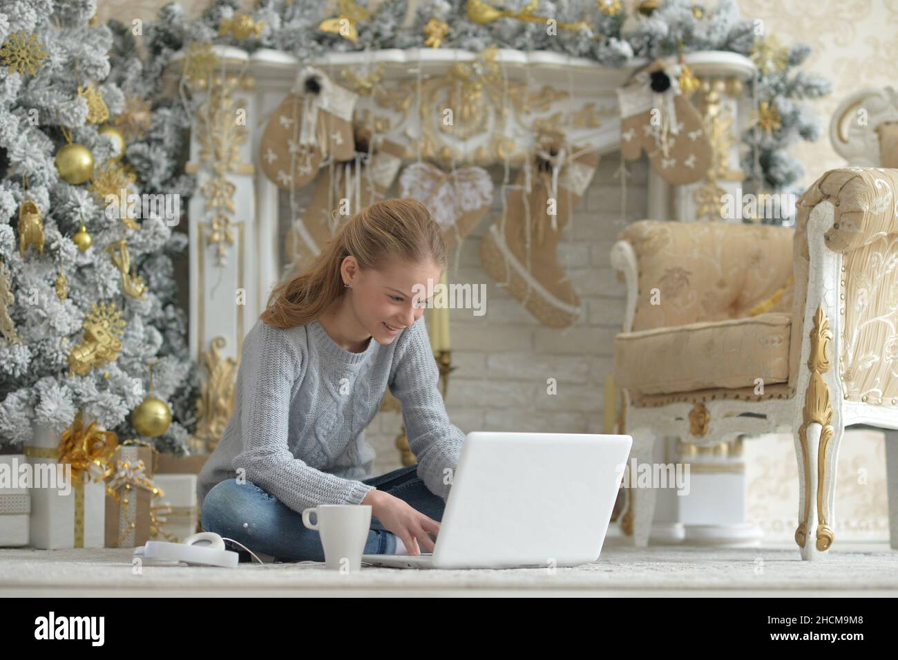Teenage girl with laptop on floor on Christmas Stock Photo - Alamy