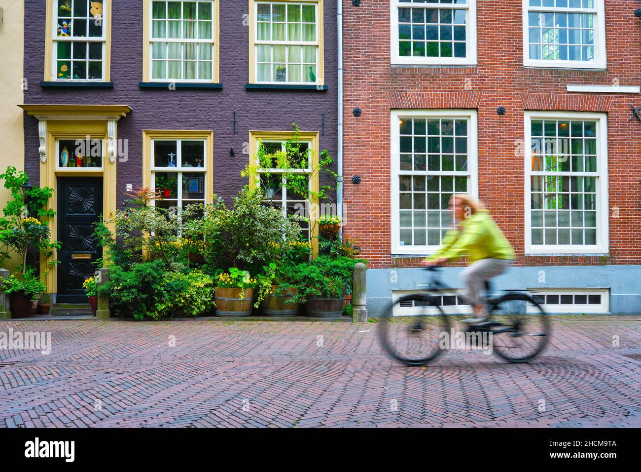 Bicycle rider cyclist woman on bicycle very popular means of transoirt in Netherlands in street of Delft, Netherlands Stock Photo
