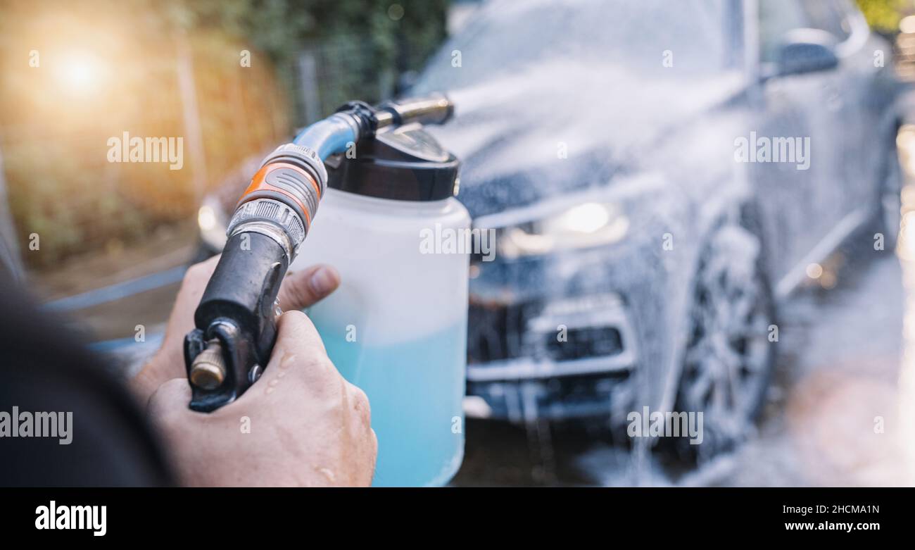 Worker Spraying foam to a SUV car with high pressure foam gun car wash