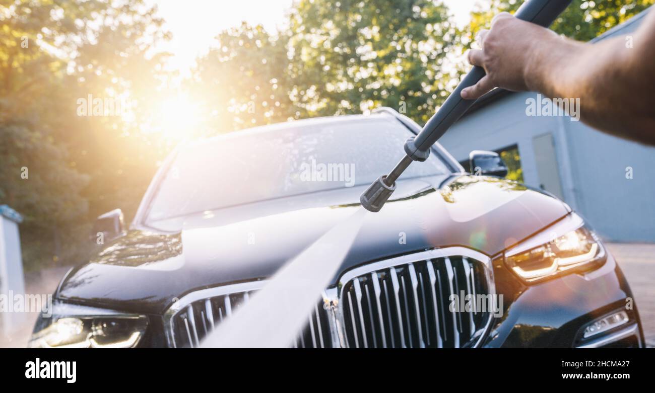 Manual car wash with pressurized water in car wash outside on a SUV Stock Photo Alamy