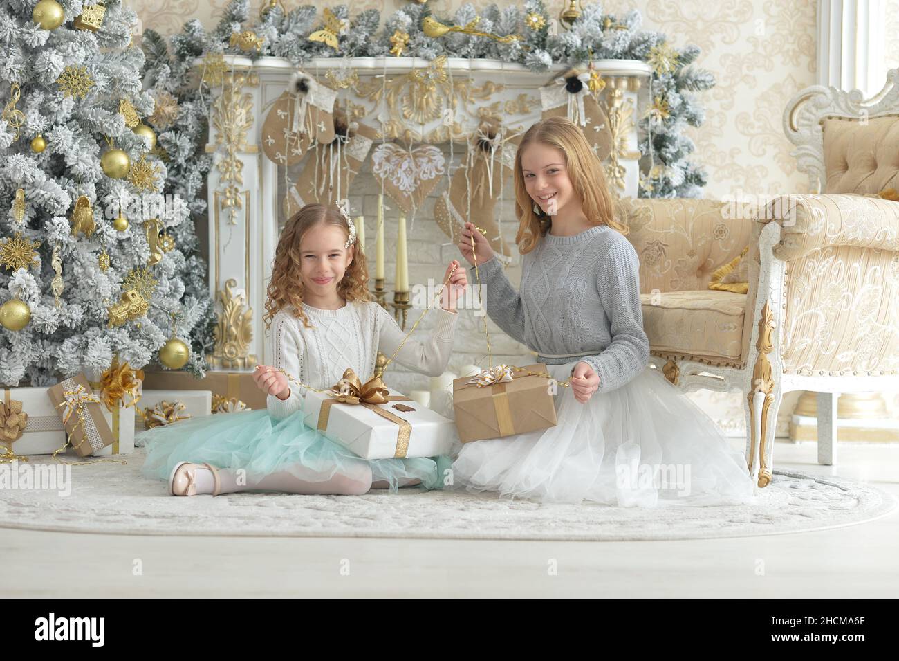 Cute girls with presents near decorated Christmas tree Stock Photo