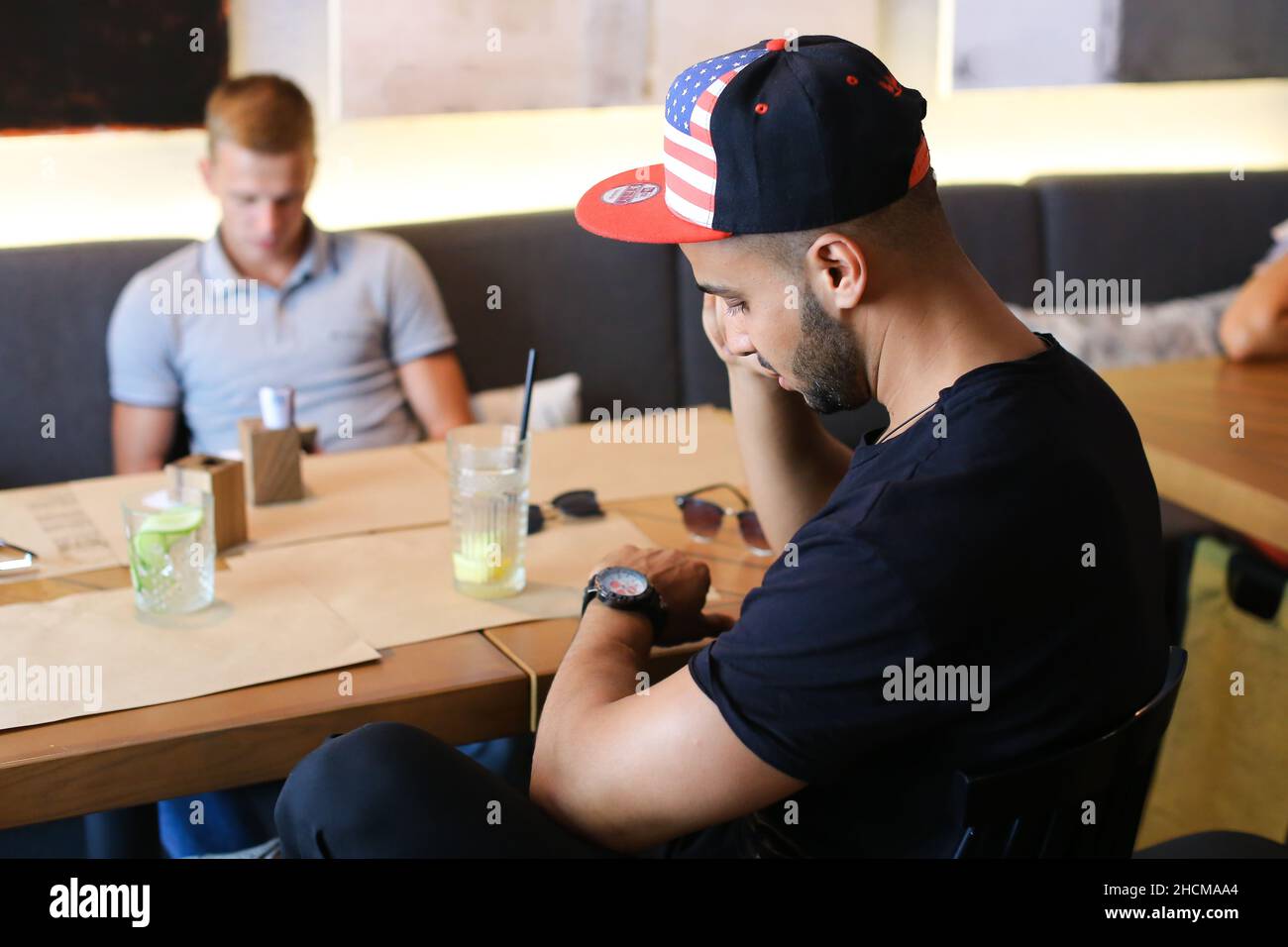 Male friends in cafe talk discuss with technology phone tablet Stock Photo