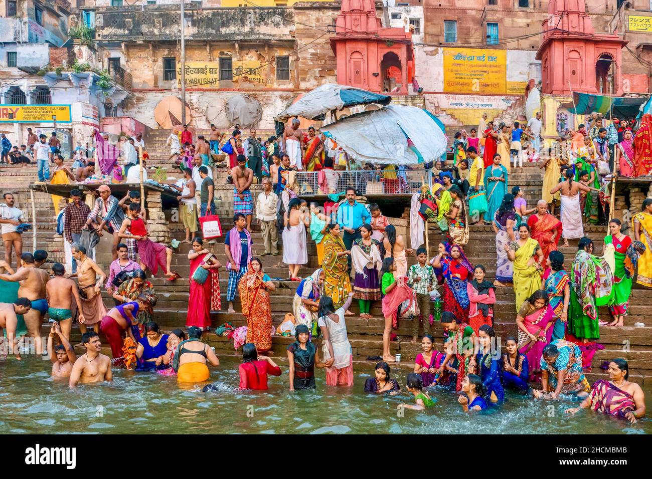Varanasi, India - November 11, 2015. A large group of Indian religious pilgrims standing on a ghat and bathing in the Ganges River, a ritual in Hindui Stock Photo