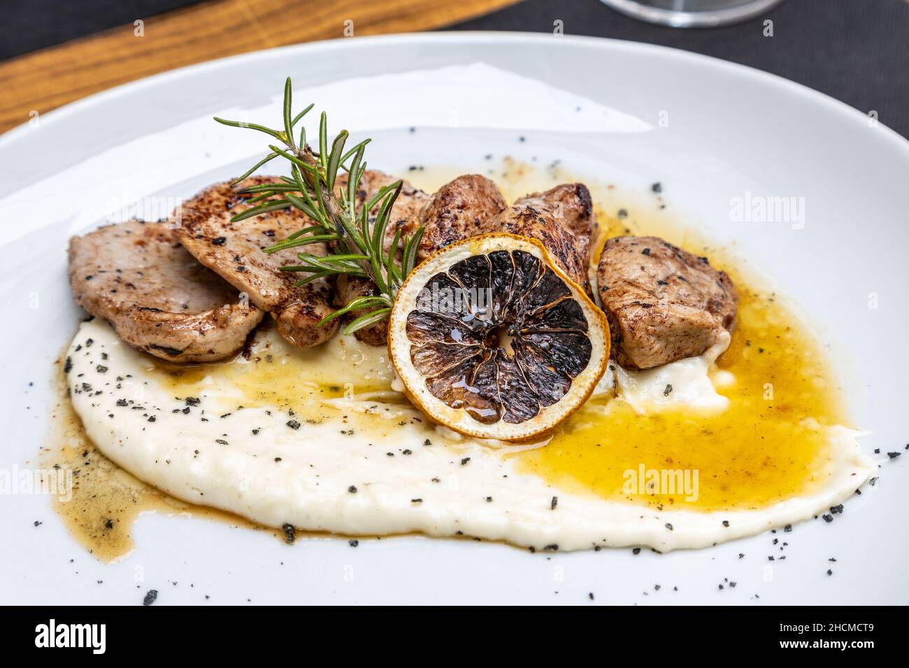 Closeup shot of cheese and grilled meat meal with a tranche of lemon Stock Photo