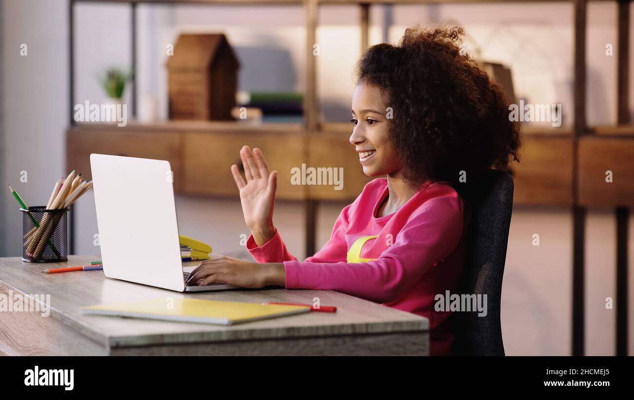 happy african american child waving hand while having video chat on ...