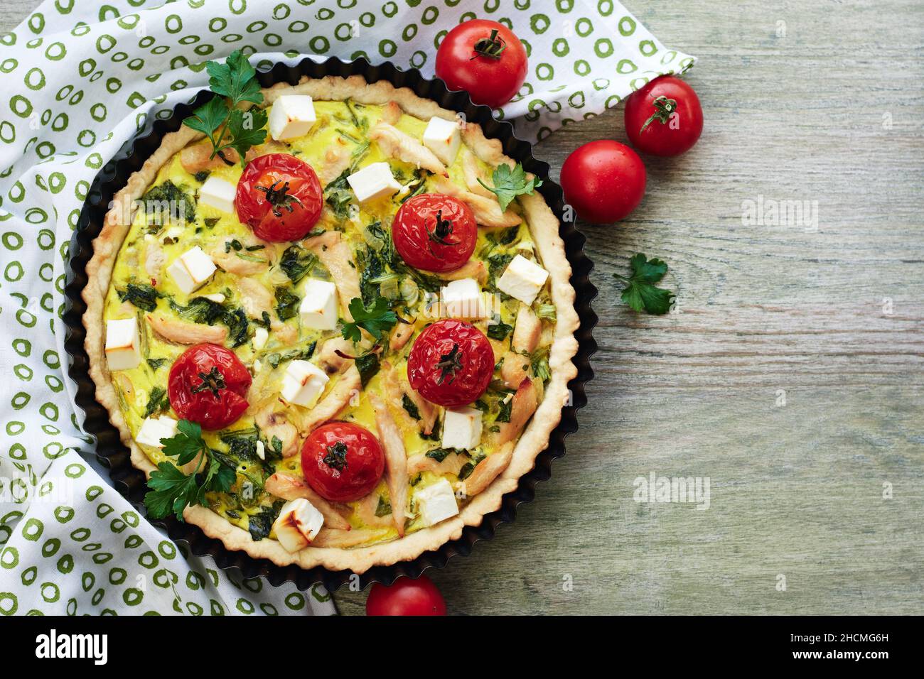 Quiche pie with chicken meat, tomatoes, spinach and cheese. Stock Photo