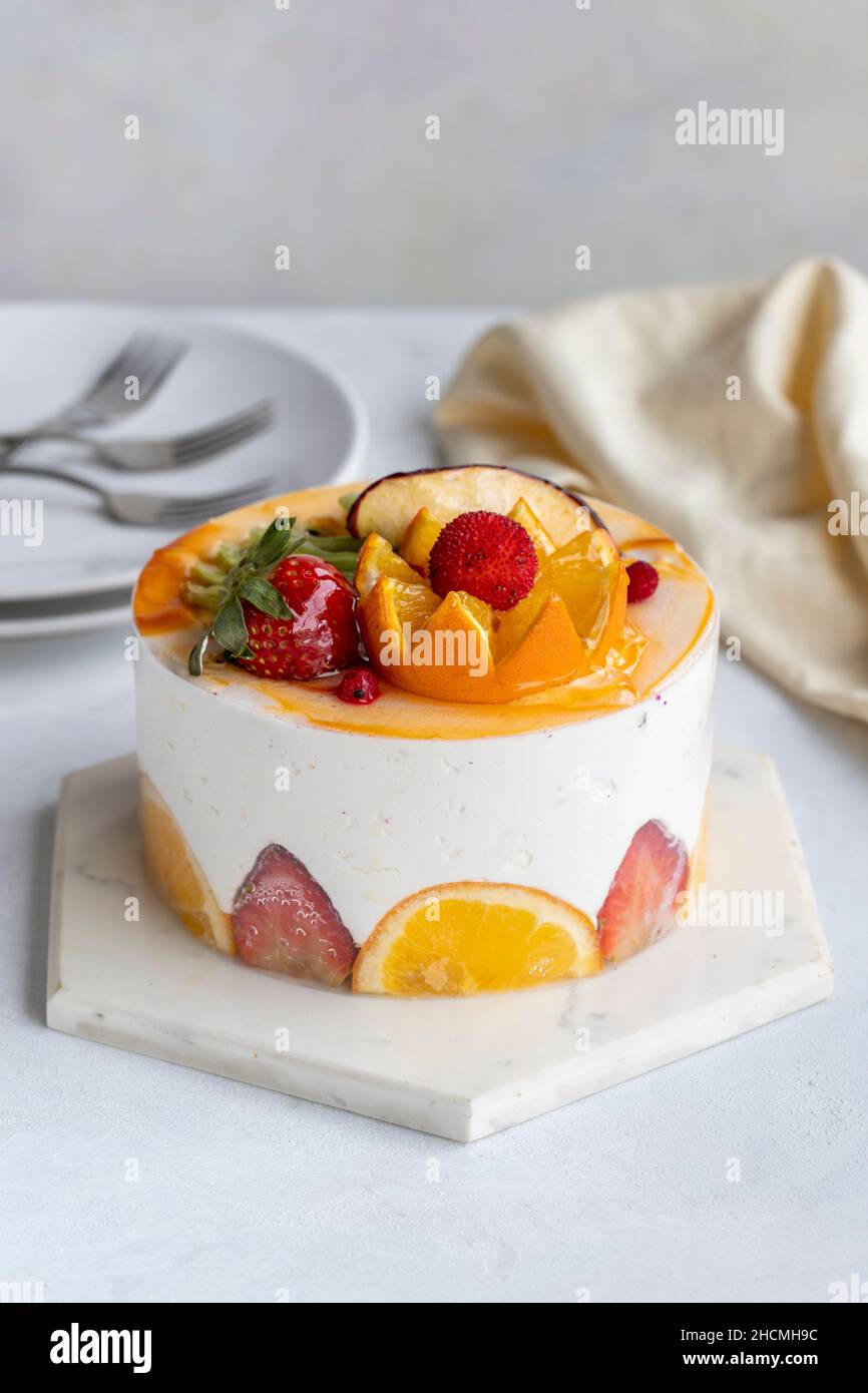Fruit Parfait Cake on a white background. Fruit cake with white cream. Close-up. Vertical view Stock Photo