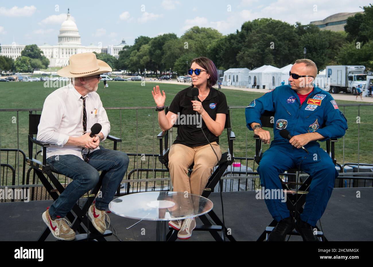 NASA Spacesuit Engineer, Lindsay Aitchison, center, speaks to Adam Savage, maker and host of Savage Builds,  along with NASA astronaut Randy Bresnik, right, during “NASA’s Giant Leaps: Past and Future,' a live television program on Friday, July 19, 2019 on the National Mall in Washington. NASA and the world are recognizing the 50th anniversary of Apollo 11, in which astronauts Neil Armstrong, Michael Collins, and Buzz Aldrin crewed the first mission to land astronauts on the Moon. Photo Credit: (NASA/Aubrey Gemignani) Stock Photo
