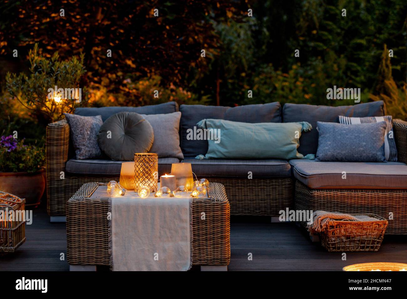 Warm summer night in the garden with trendy furniture, lights, lanterns and candles Stock Photo