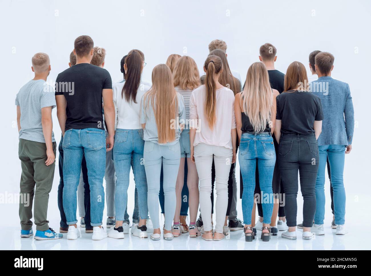 group of diverse young people standing in front of a white wall Stock ...