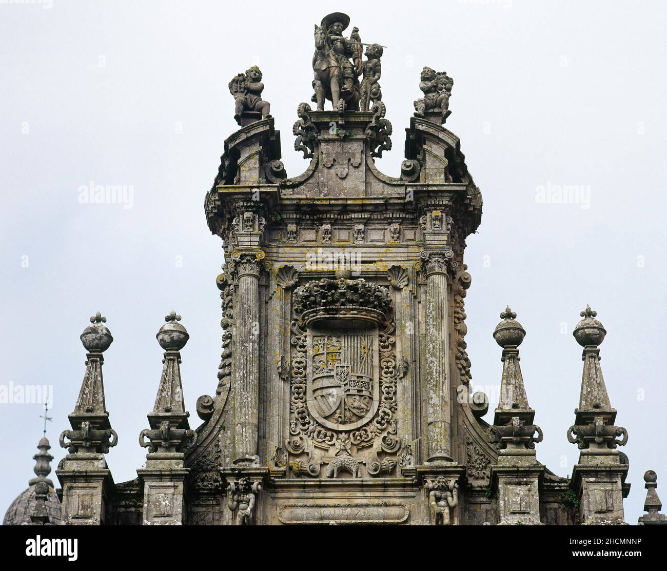 Spain, Galicia, A Coruña province, Santiago de Compostela. San Martin Pinario Monastery. Architectural detail of the structure added in 1738 by Fernando de Casas Nóvoa (ca.1700-1749), to complete the façade, with the arms of Spain between scallops, and the equestrian image of Saint Martin of Tours sharing his cloak with a beggar who represents to Christ. Stock Photo
