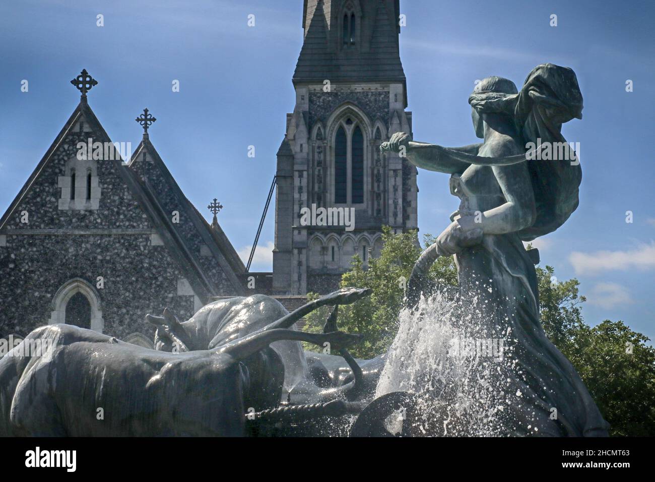 Copenhagen, Denmark - St. Alban's English Church in Gothic Revival style and goddess Gefion fountain from 1908,the largest monument in Copenhagen Stock Photo
