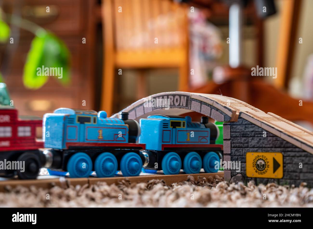 Tiffin, Iowa, USA - 3.2021: Small boy playing with a model Thomas the Train. Thomas is a popular railroad themed children's' toy.  Stock Photo