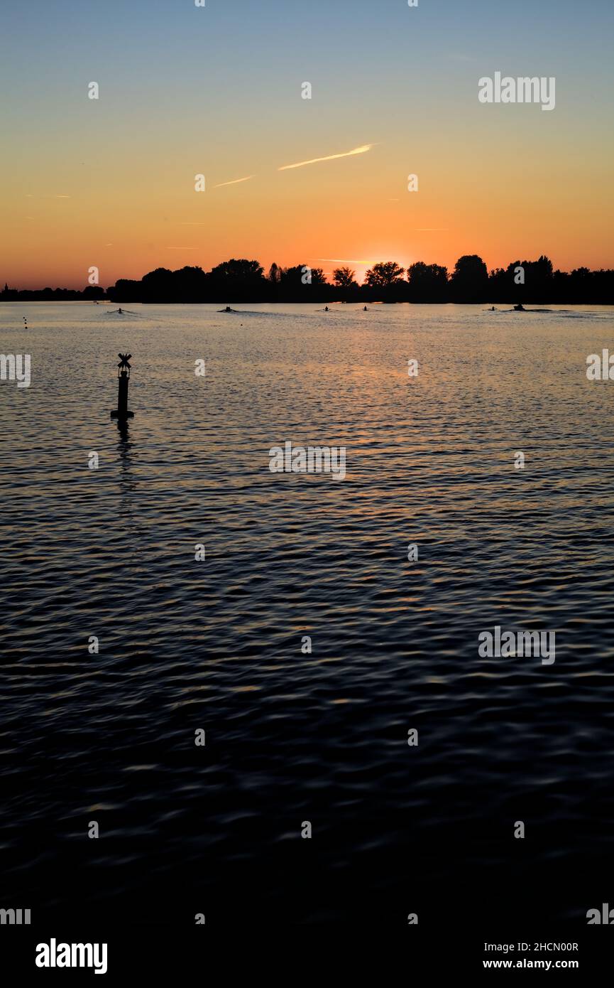 Sunset over a lake with a forest in the backdrop Stock Photo - Alamy