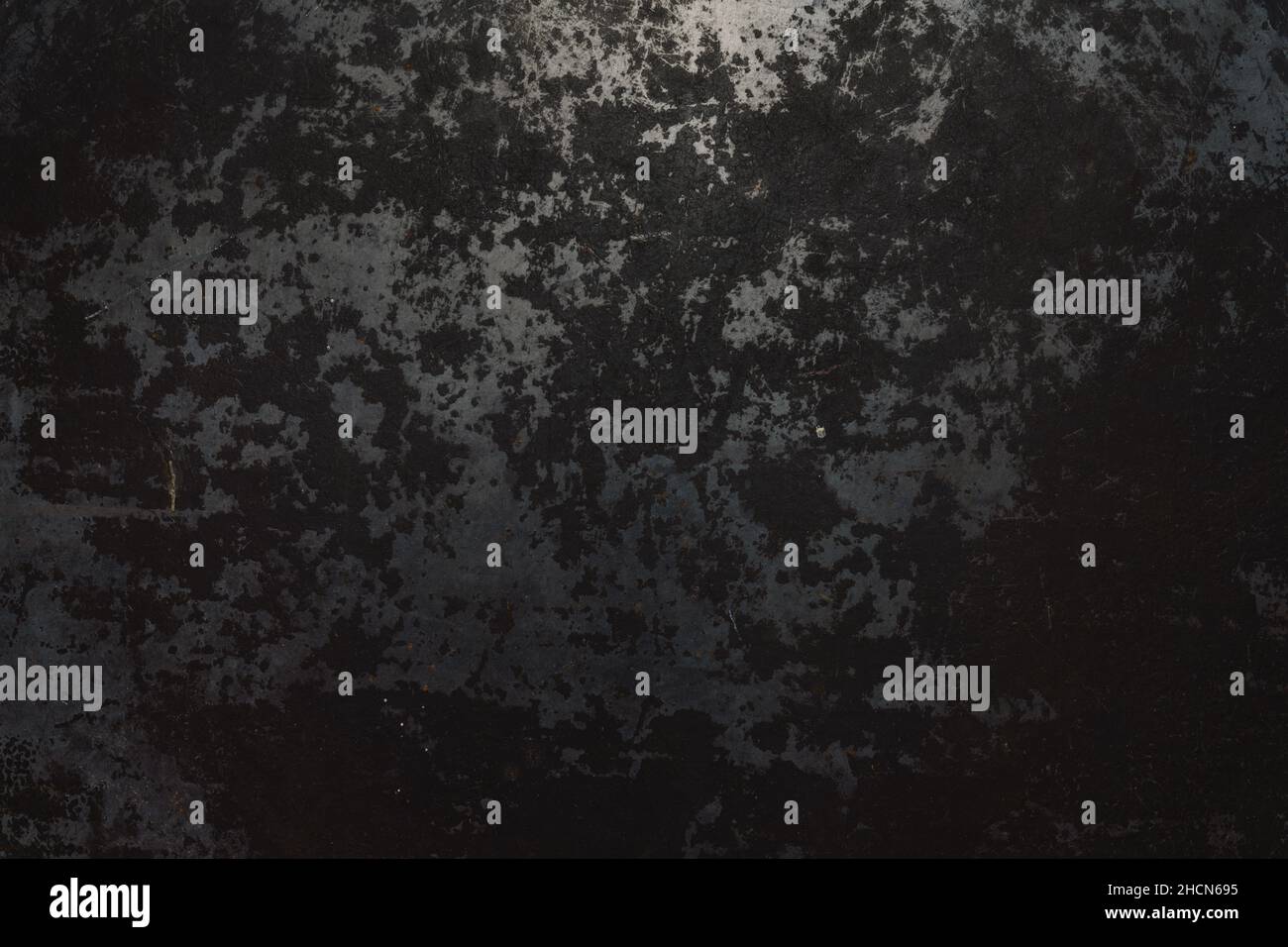 Rough, dark metal background lit by spotlight background Stock Photo