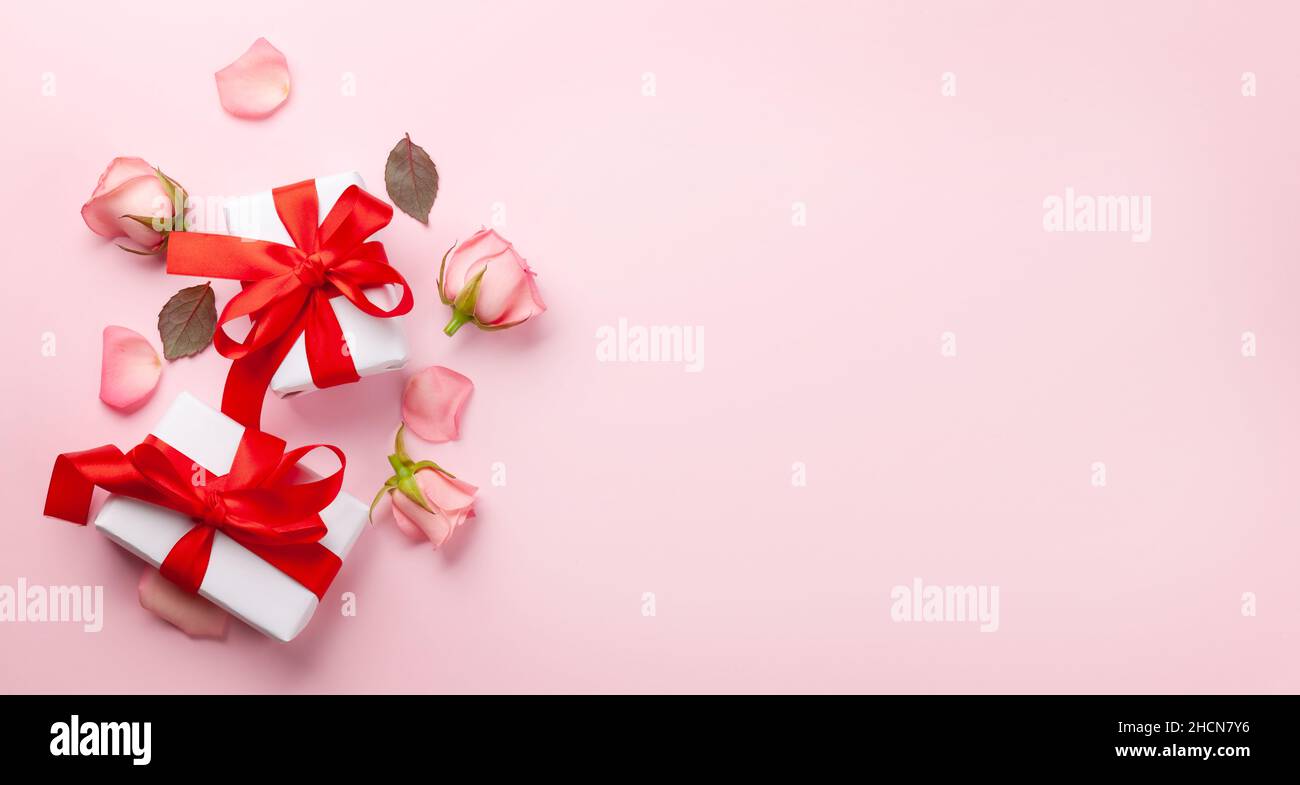 Gift boxes and rose flowers petals. Valentines day greeting card with ...