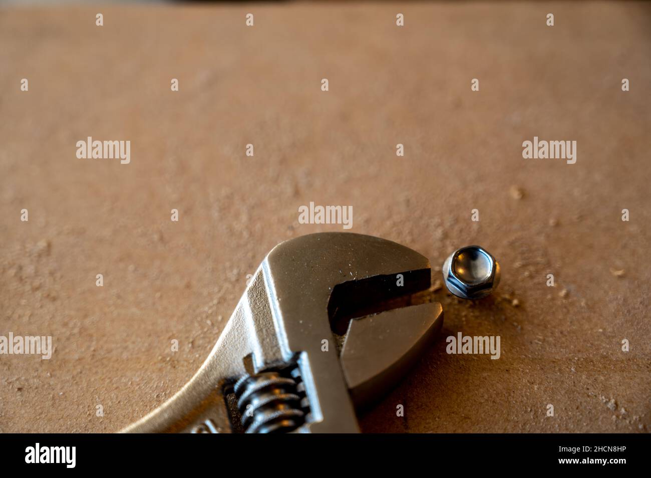 rounded stuck bolt head next to a crescent wrench Stock Photo Alamy