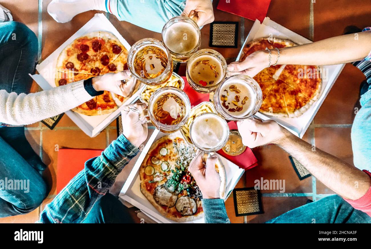 Young friends roomates eating take away pizza at home after college - Friendship concept with people students enjoying time together and having fun Stock Photo