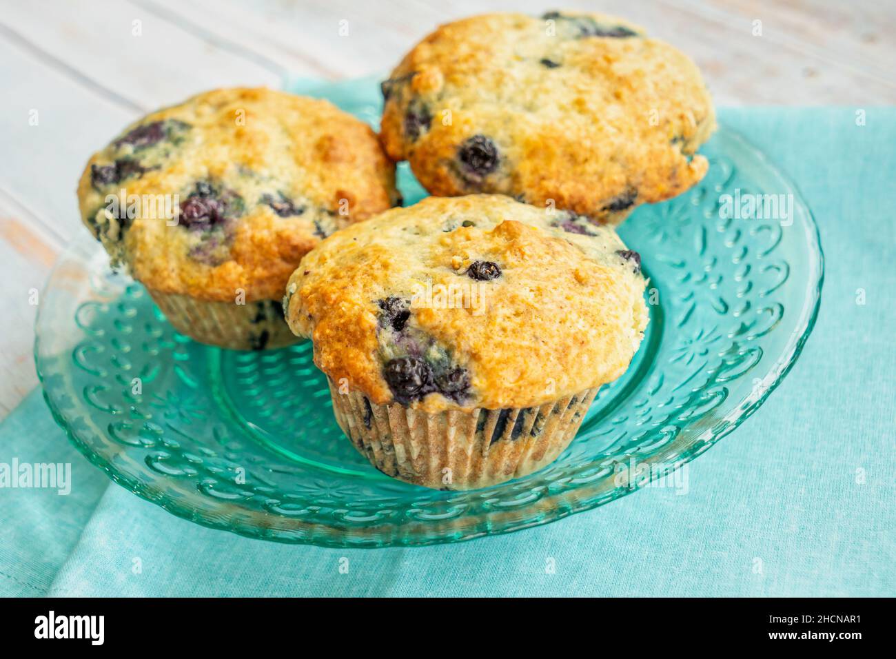 Homemade blueberry muffins on a teal glass plate. Stock Photo