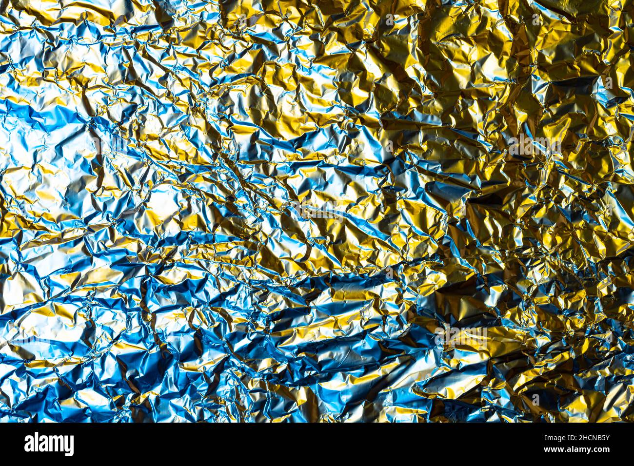crumpled foil background illuminated with colored lights Stock Photo