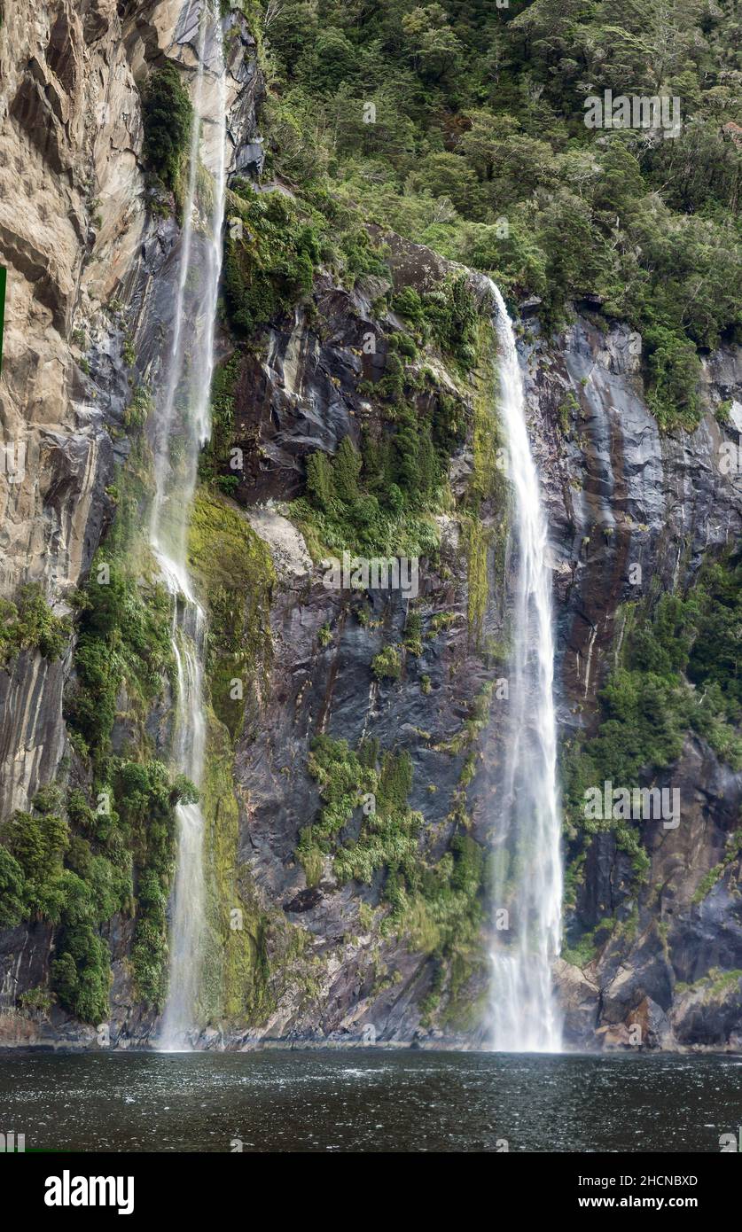 Waterfall cascading down the mountainside in Milford Sound, part of the Fiordland National Park, South Island, New Zeland Stock Photo